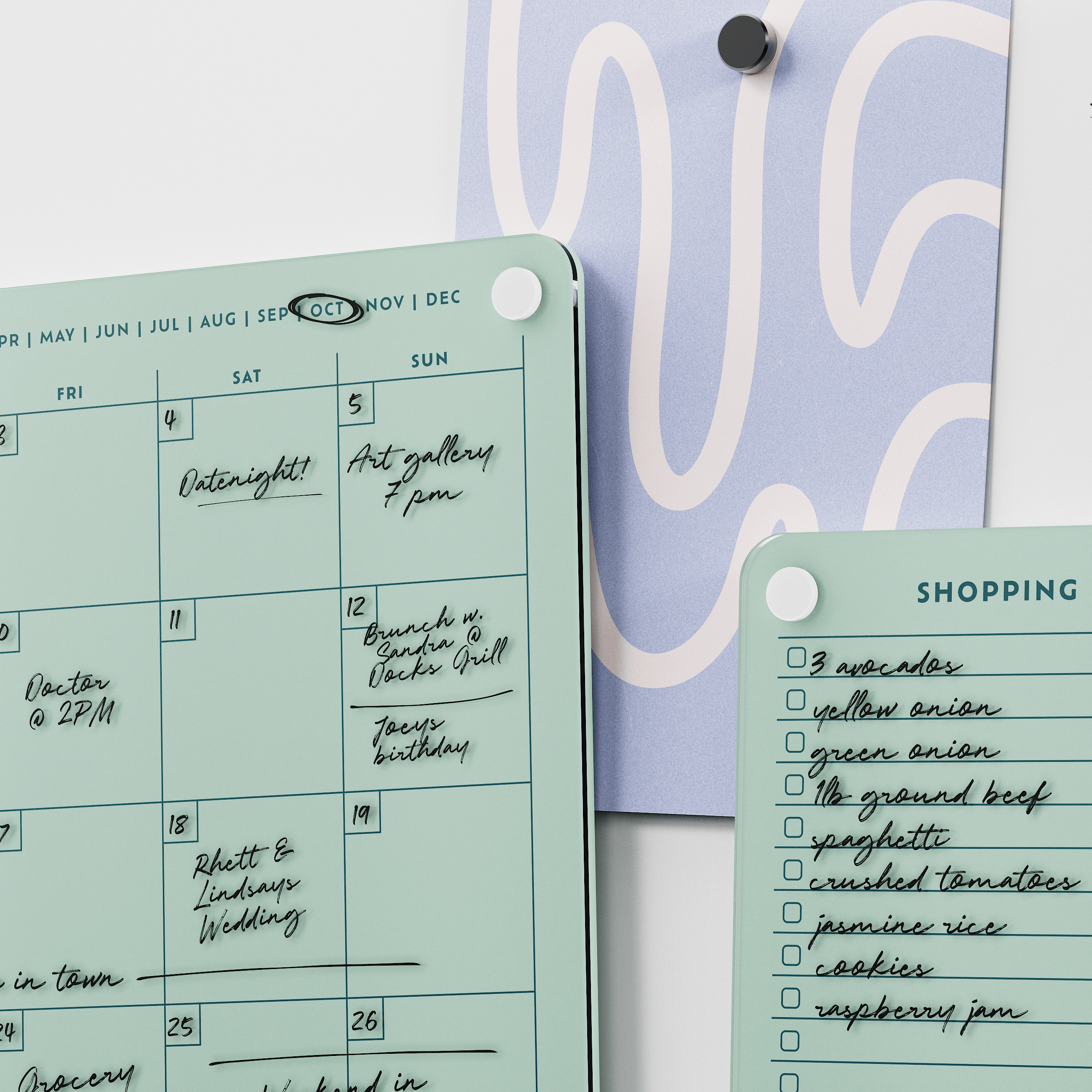 Close-up of the Seafoam green monthly calendar and shopping list boards with handwritten plans and groceries